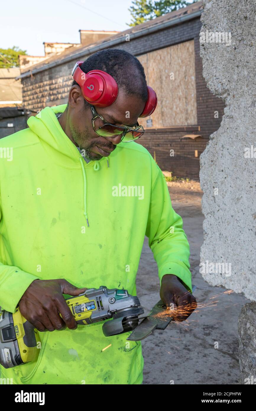 Detroit, Michigan - UN lavoratore del Detroit Grounds Crew affina una lama di falciatrice prima che il suo equipaggio tagli l'erba sulla base di un sch pubblico chiuso Foto Stock