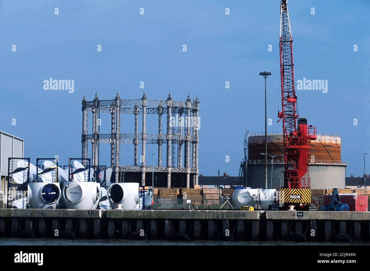 Componenti per turbine eoliche Vestas con un asometro di epoca vittoriana, porto di Great Yarmouth, Norfolk, Regno Unito. Foto Stock