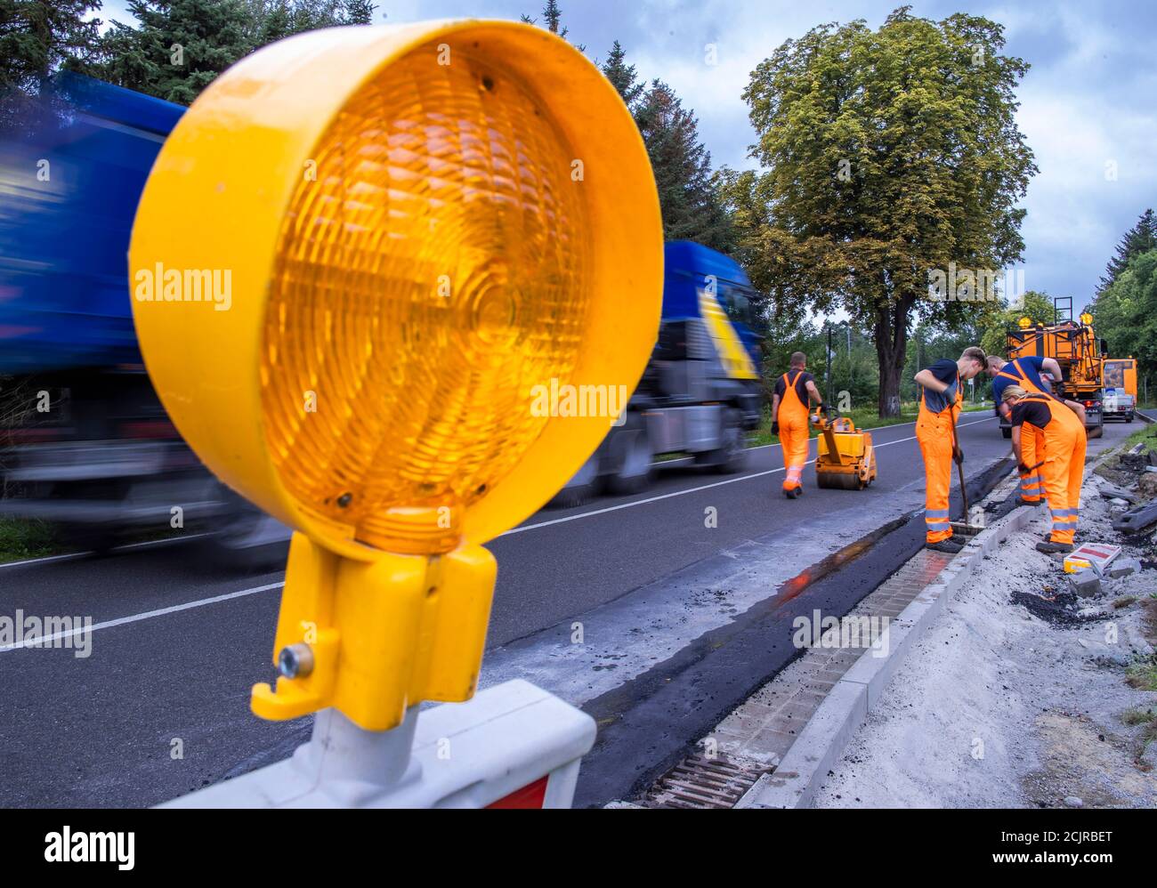 09 settembre 2020, Meclemburgo-Pomerania occidentale, Gnoien: Apprendisti nel secondo anno di formazione su una fermata dell'autobus per riparare i danni e applicare una nuova superficie stradale. I futuri addetti alla manutenzione stradale del Meclemburgo-Pomerania occidentale sono addestrati nel reparto di manutenzione stradale di Teterow. Il reparto di manutenzione stradale è responsabile di circa 200 chilometri di strade statali e federali. Foto: Jens Büttner/dpa-Zentralbild/ZB Foto Stock