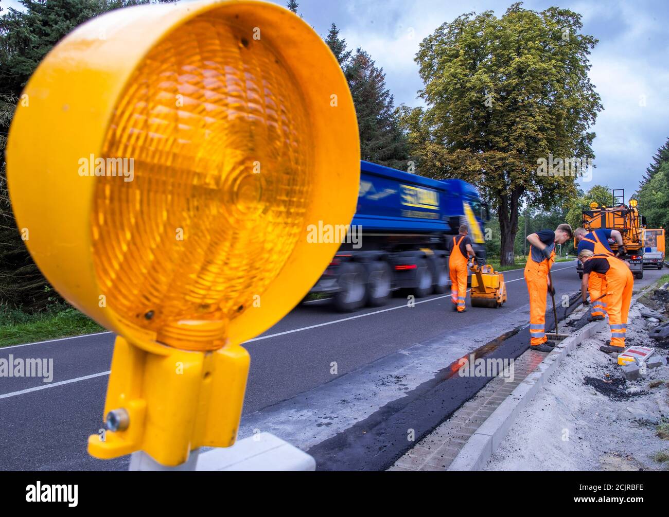 09 settembre 2020, Meclemburgo-Pomerania occidentale, Gnoien: Apprendisti nel secondo anno di formazione su una fermata dell'autobus per riparare i danni e applicare una nuova superficie stradale. I futuri addetti alla manutenzione stradale del Meclemburgo-Pomerania occidentale sono addestrati nel reparto di manutenzione stradale di Teterow. Il reparto di manutenzione stradale è responsabile di circa 200 chilometri di strade statali e federali. Foto: Jens Büttner/dpa-Zentralbild/ZB Foto Stock