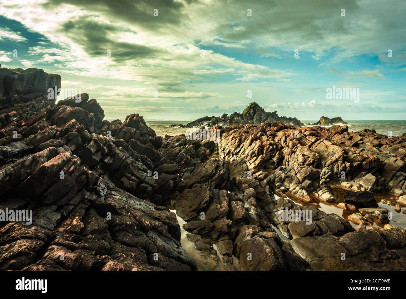la formazione naturale di roccia a riva del mare a causa delle onde che si infrangono al mattino da un'immagine ad angolo piatto è presa alla spiaggia om gokarna karnataka india Foto Stock