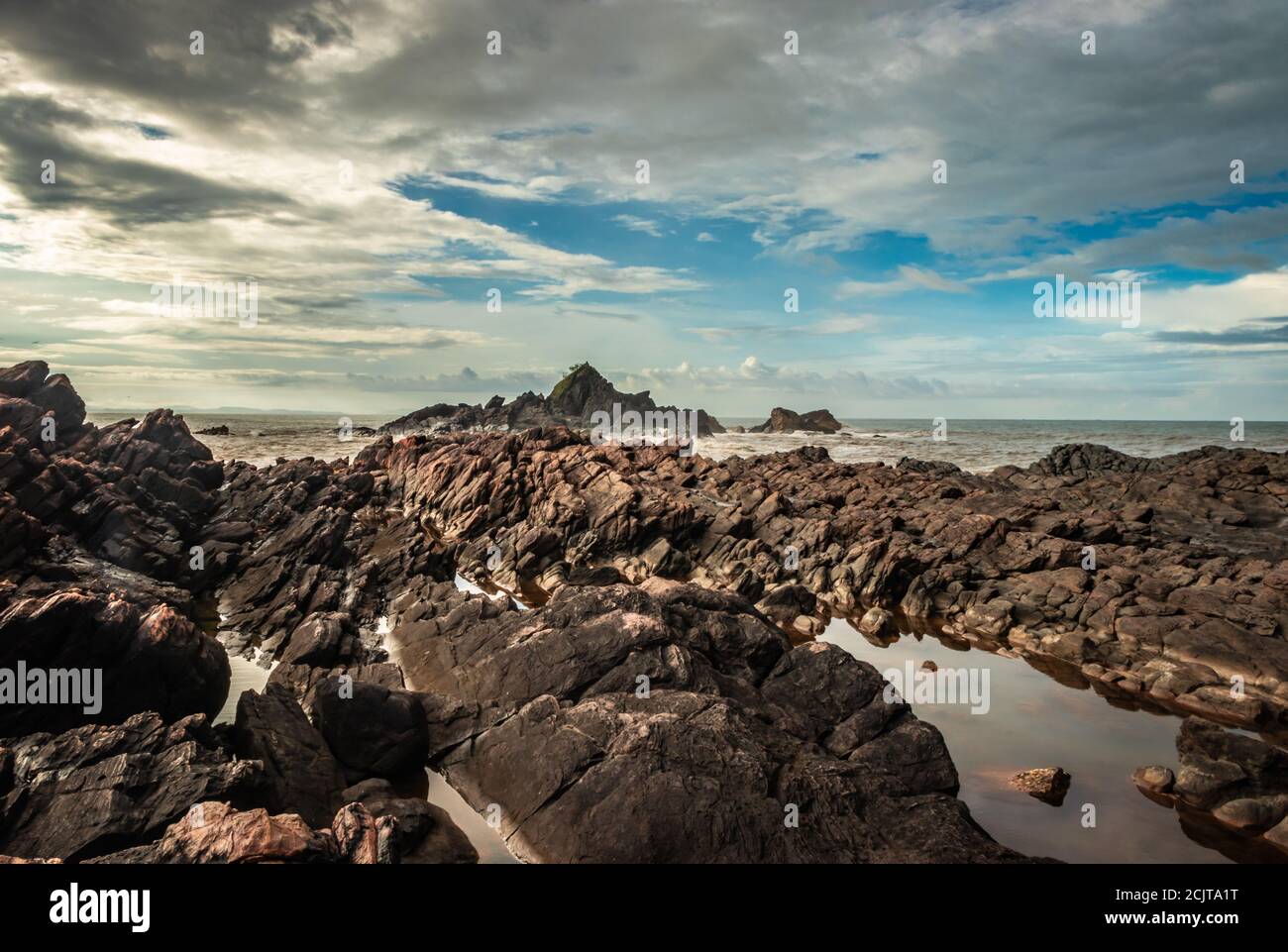 la formazione naturale di roccia a riva del mare a causa delle onde che si infrangono al mattino da un'immagine ad angolo piatto è presa alla spiaggia om gokarna karnataka india Foto Stock