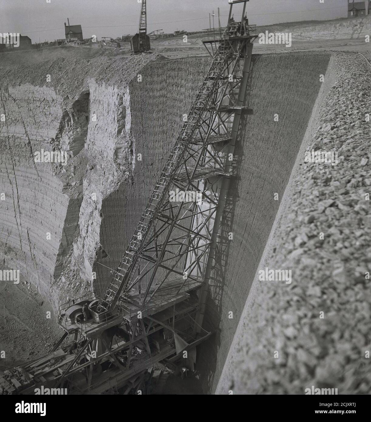 Anni '50, immagine storica della ripida scalinata in metallo sulla cima di un scavatore meccanico o un escavatore in una gigantesca buca di argilla o cava in un muratore nel sud-est dell'Inghilterra, Regno Unito. Foto Stock