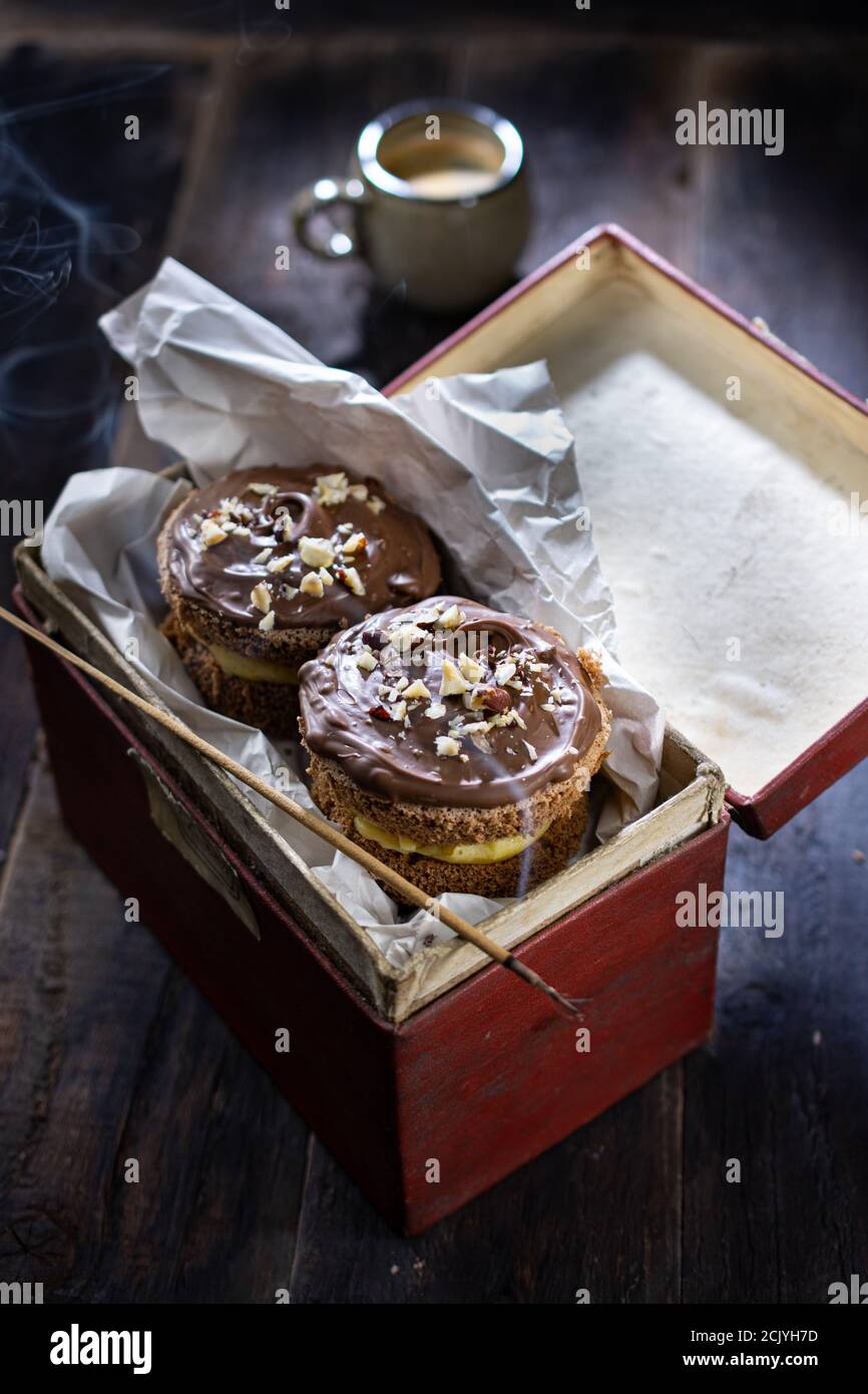 Muffin alla crema di cioccolato. Dessert dolce in scatola. Stile country. Cibo e bevande salutari. Foto Stock