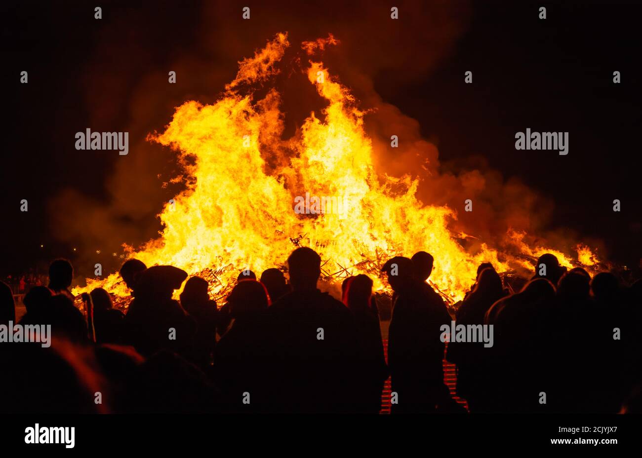 Persone in silhouette che guardano un grande falò alle celebrazioni annuali di Guy Fawkes & Bonfire Night a Littlehampton, West Sussex, Regno Unito. Foto Stock