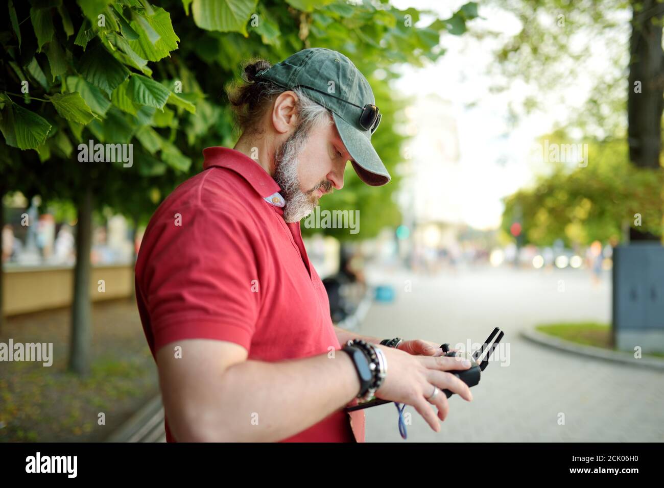 Uomo che guarda e naviga un drone. Uomo bearded che aziona il drone tramite telecomando. Foto Stock