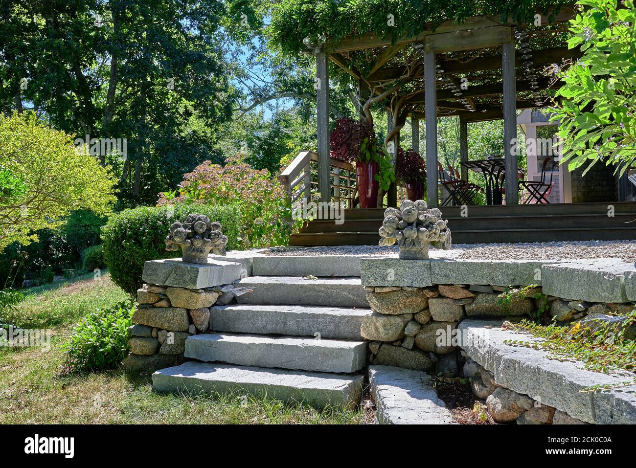 Giardino di granito passi dal prato ad una terrazza. Su ciascun lato dei gradini sono ornamenti decorativi in pietra con cesto di frutta. Foto Stock