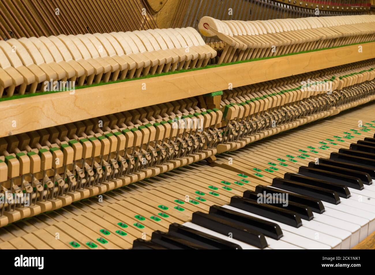 Le lavorazioni interne di un pianoforte verticale che mostra le corde e i martelli all'interno. Foto Stock