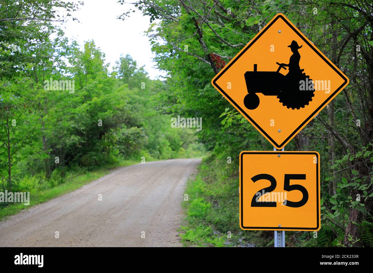 Segnale giallo di attraversamento del trattore e limite di velocità da parte di un paese Strada vicino Londonderry.Vermont.USA Foto Stock