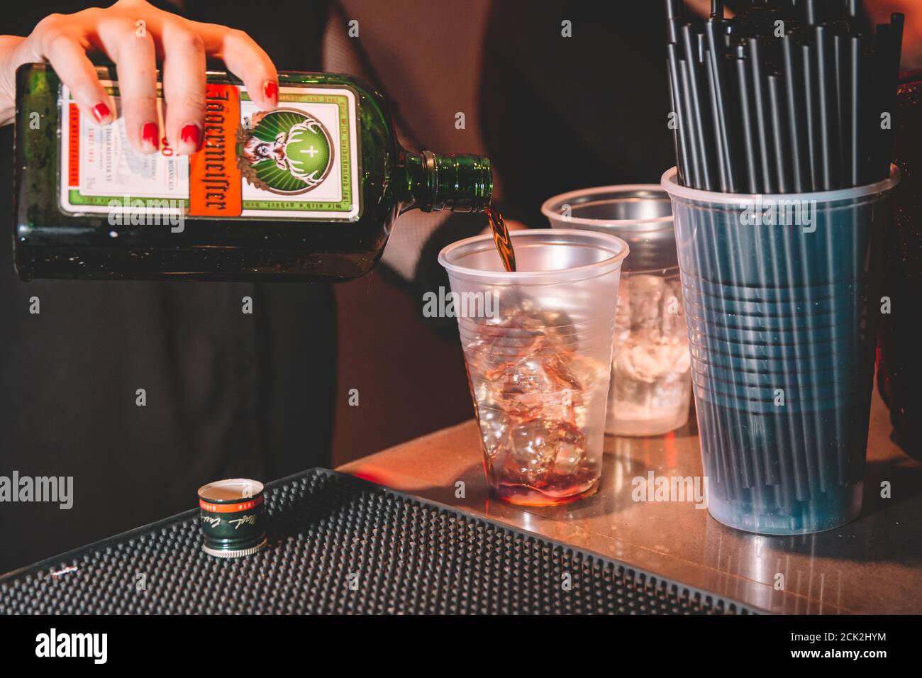 Buenos Aires, Argentina; 7 gennaio 2018: Donna che serve Jagermeister in una tazza di plastica con ghiaccio. Foto Stock