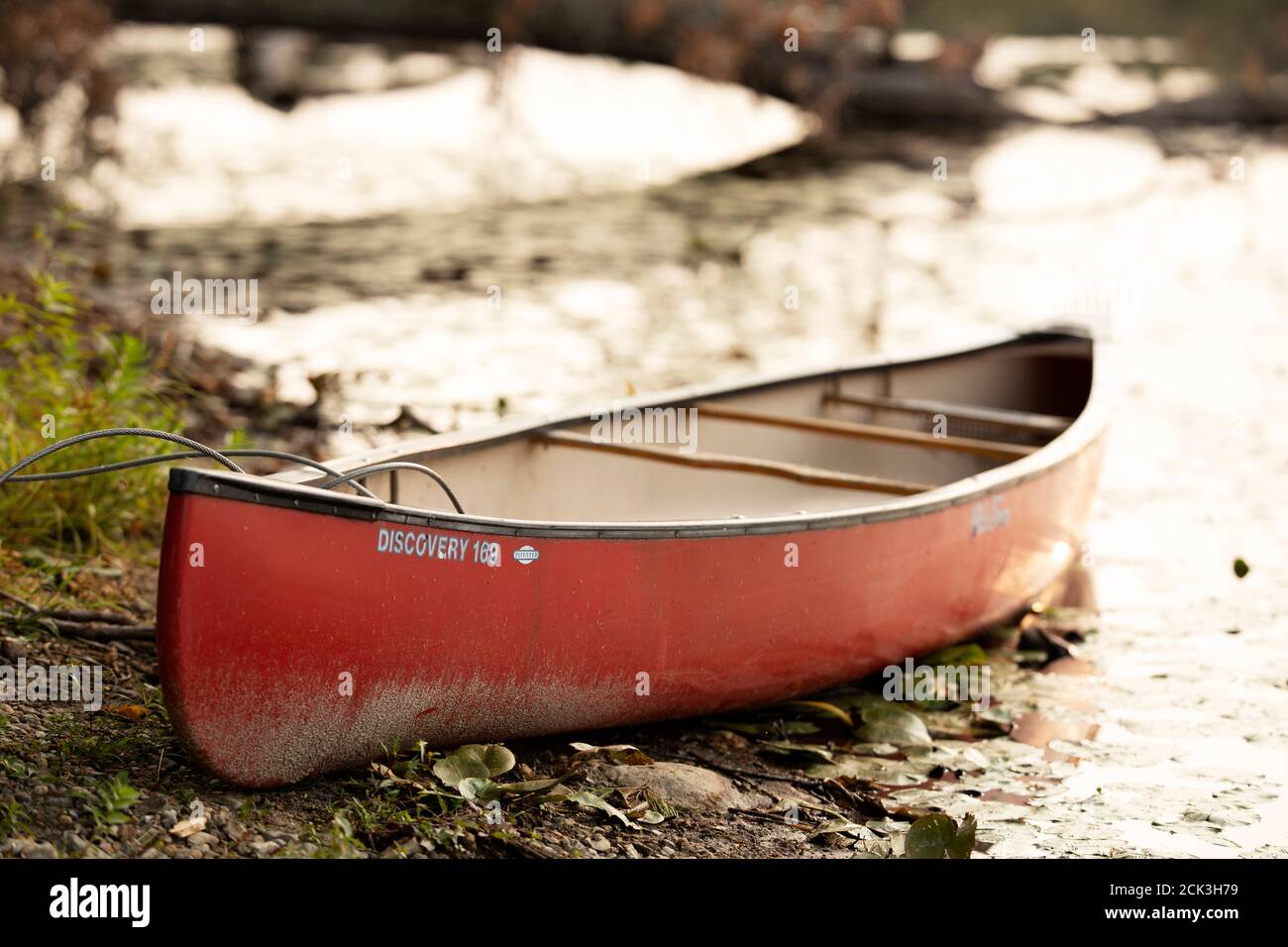 Una canoa rossa si trova sulla riva del lago Long a Littleton, Massachusetts, USA. Foto Stock