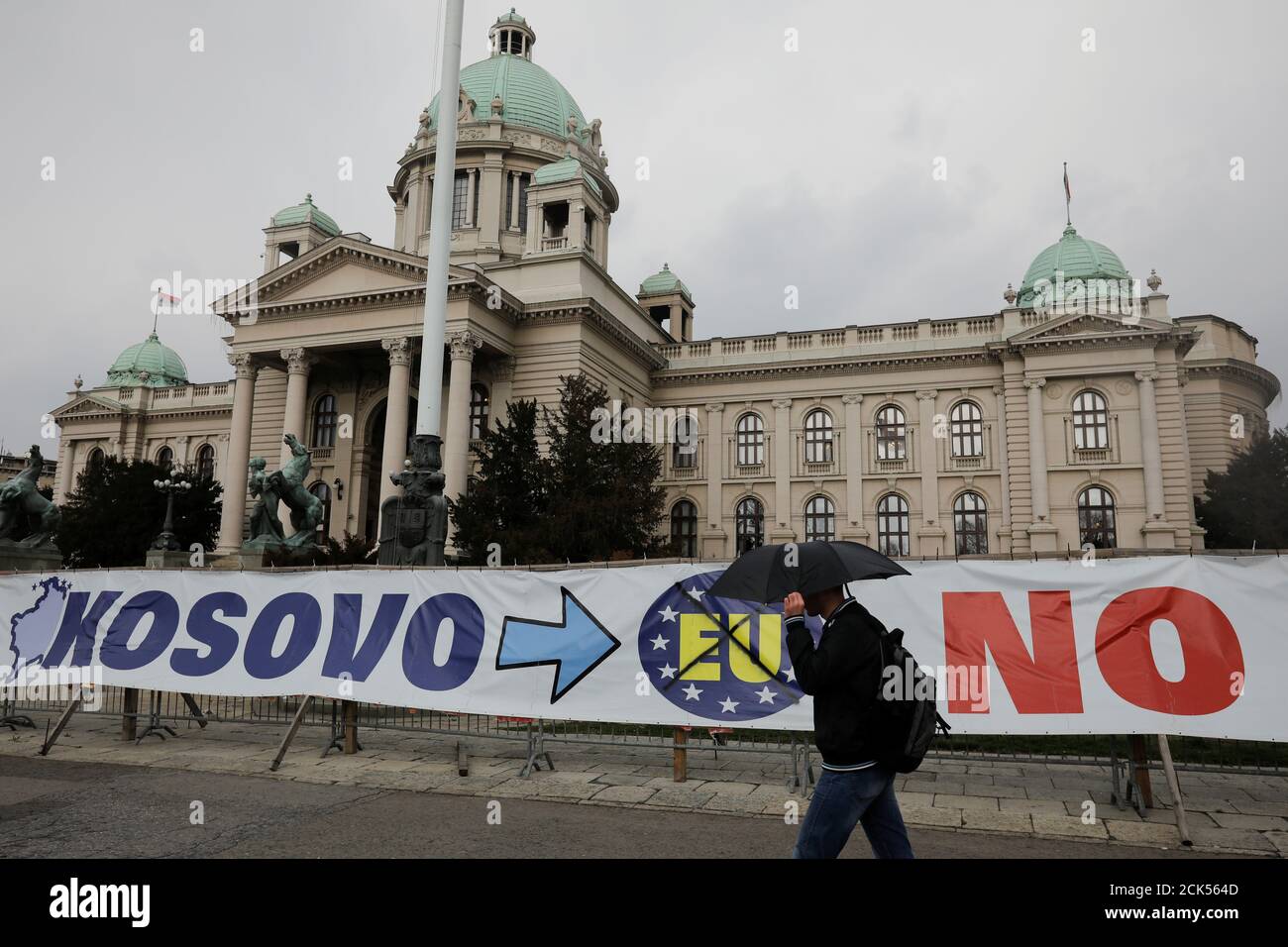 Un uomo passa davanti a un cartello di fronte all'edificio del parlamento serbo nel centro di Belgrado, Serbia, 27 marzo 2018. REUTERS/Marko Djurica Foto Stock