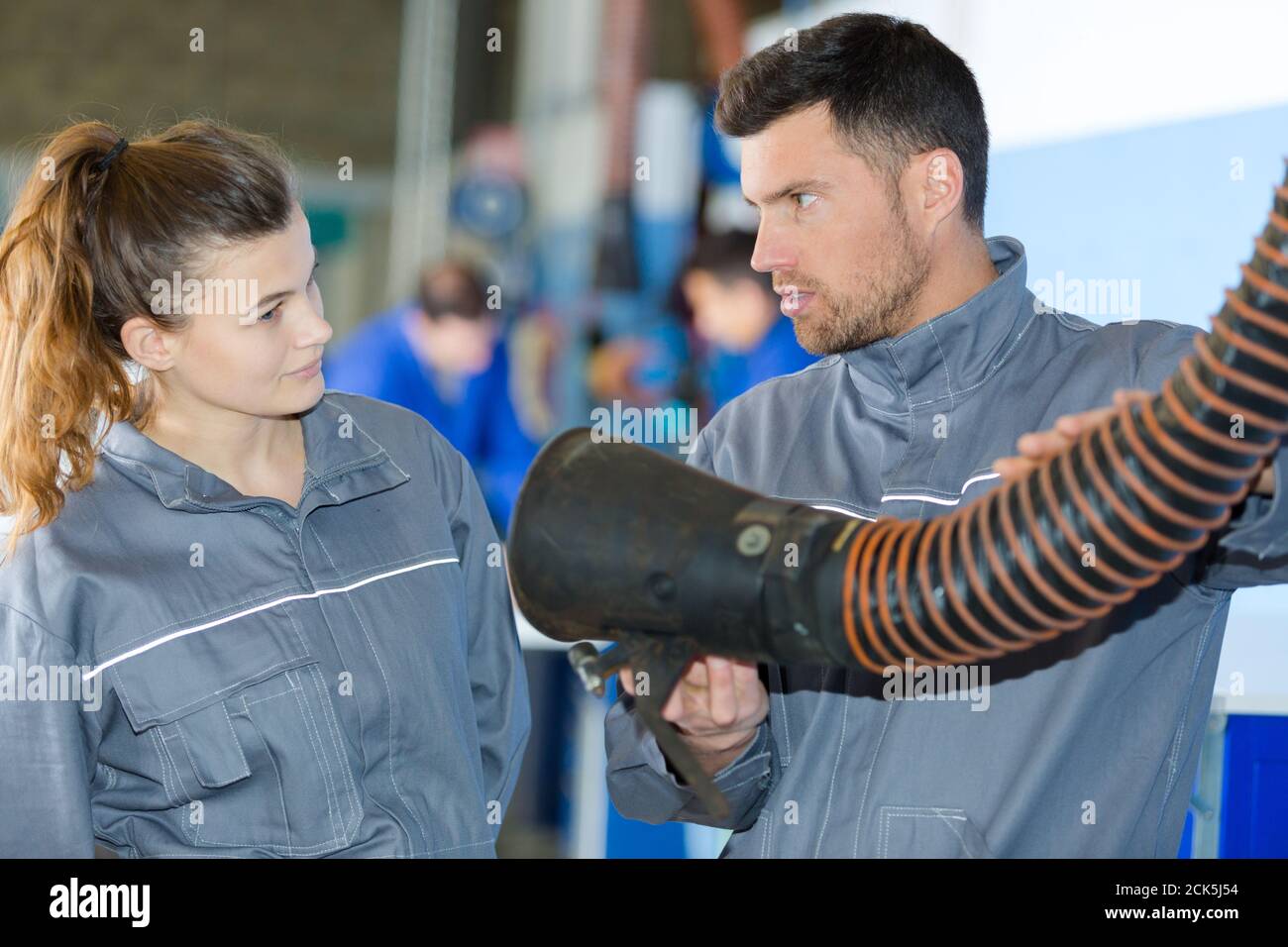 lavoratore maschile che mostra un'attrezzatura industriale Foto Stock