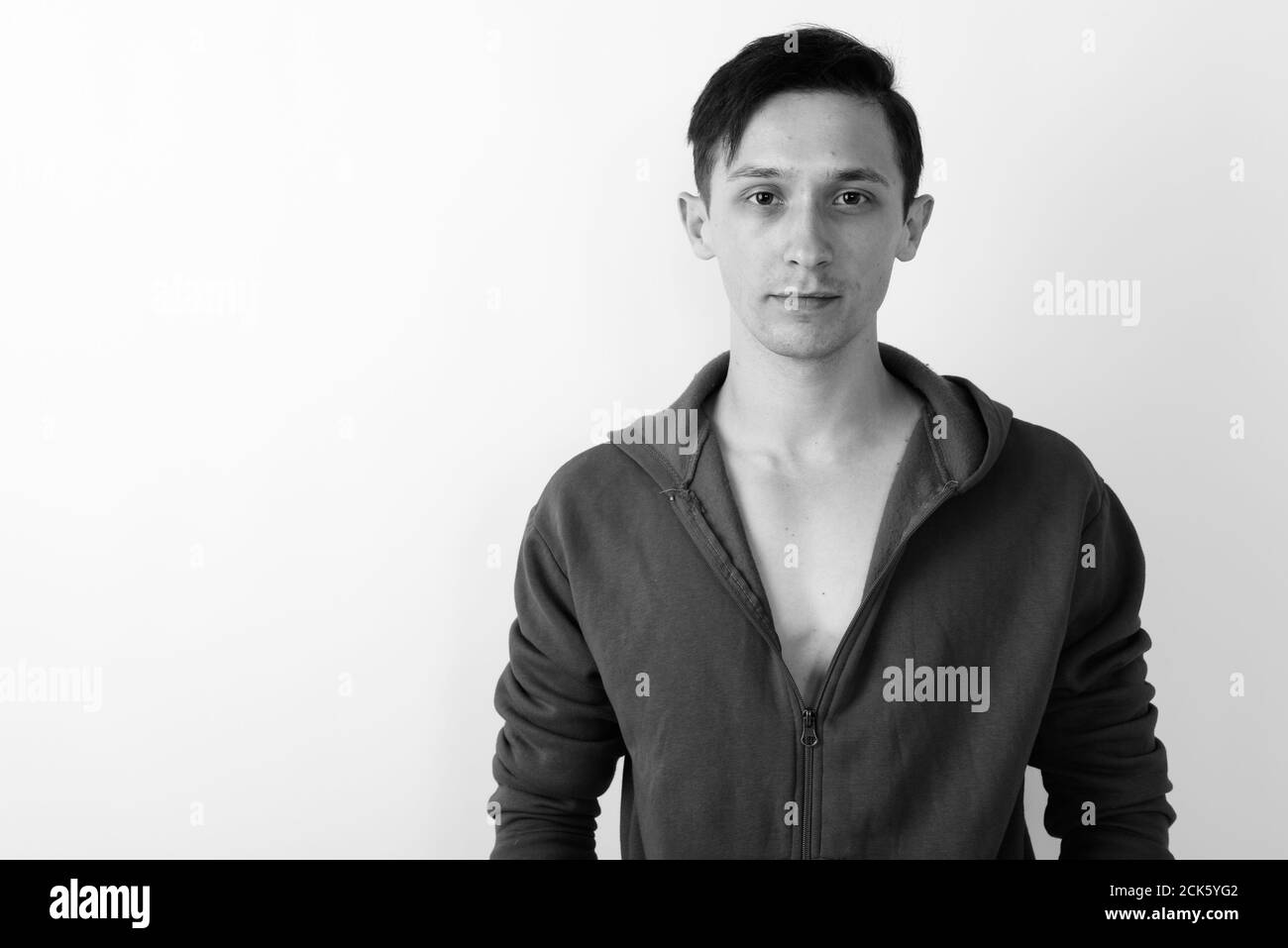 Studio di un giovane bell'uomo che indossa una felpa con cappuccio rossa sfondo bianco Foto Stock