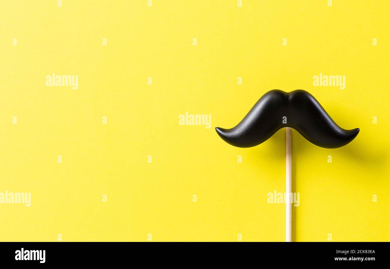 Concetto del giorno del Padre. Baffi neri su sfondo di carta giallo. Foto Stock