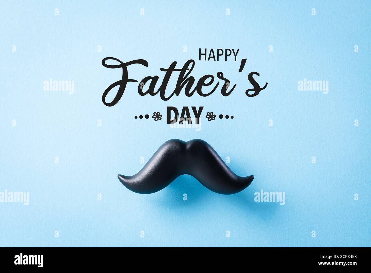 Concetto del giorno del Padre. Baffi neri su sfondo di carta blu. Foto Stock