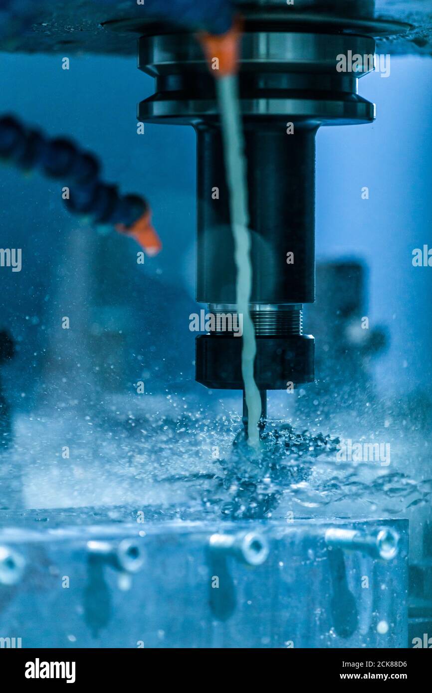 Una vista ravvicinata su trucioli avvolti sulla punta in carburo mentre si fora cnc sotto il liquido di raffreddamento. Problema di regolazione della velocità di avanzamento e di taglio. Foto Stock