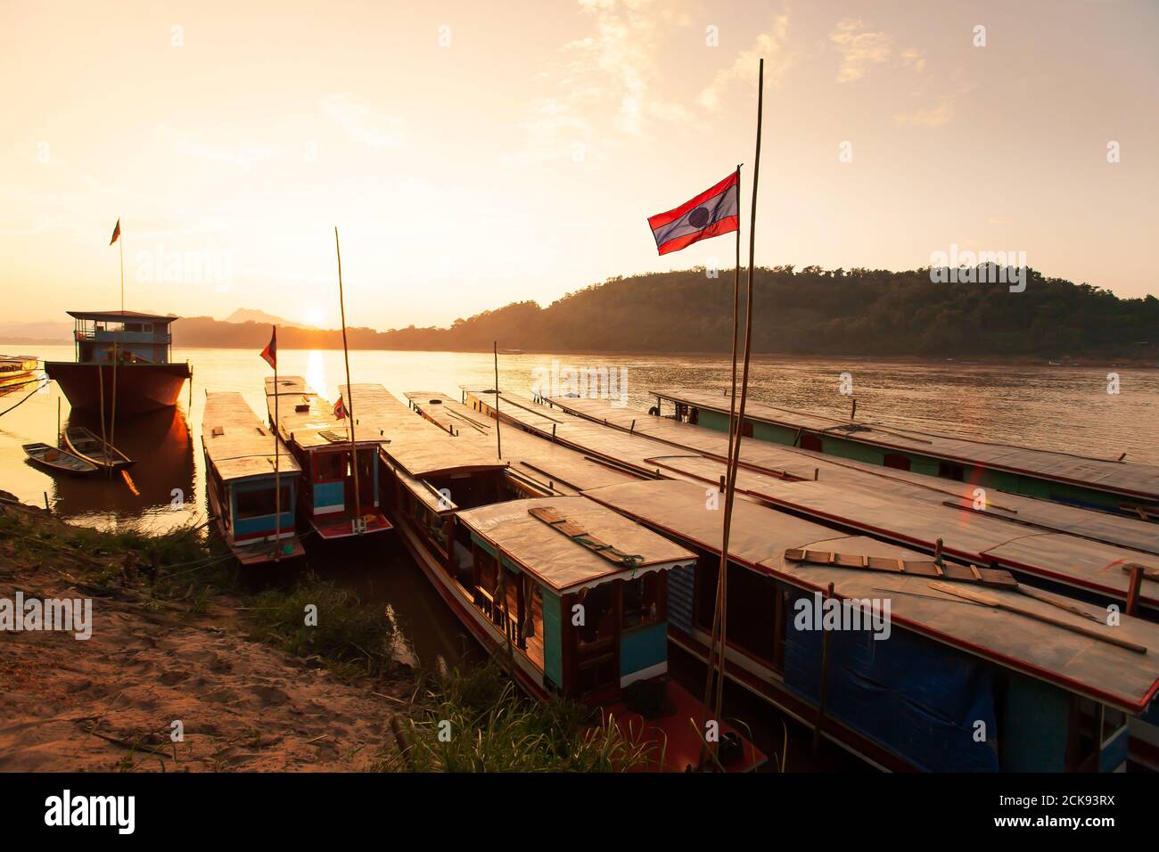 Paesaggio del fiume Mekong al tramonto, un sacco di traghetto tradizionale in legno presso un porto locale. Luang Prabang, Laos. Foto Stock