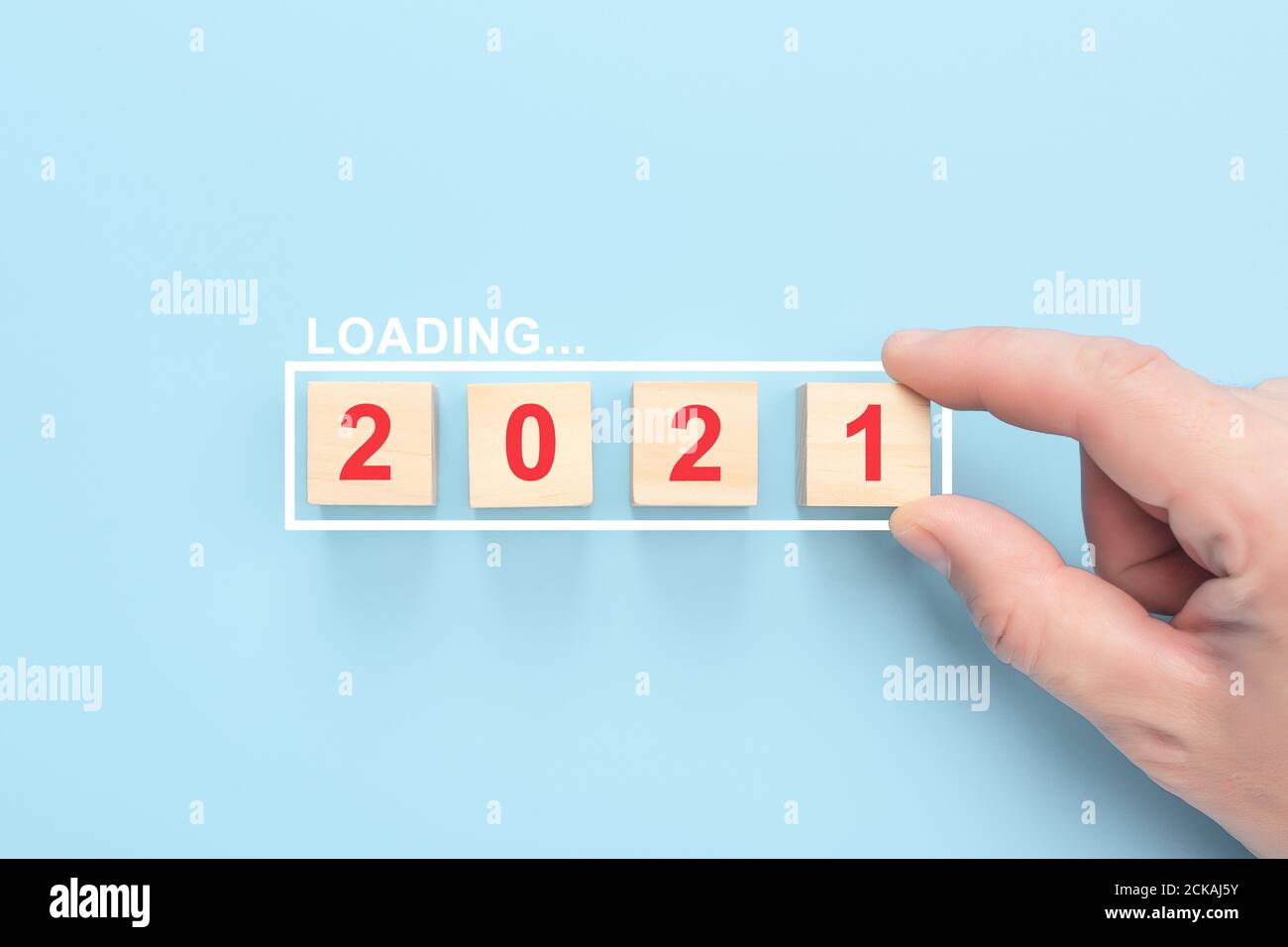 Caricamento 2021 anni su cubi di legno su sfondo blu. Mano mettendo cubo di legno in barra di avanzamento. Caricamento nuovo anno 2021 con mano dell'uomo Foto Stock