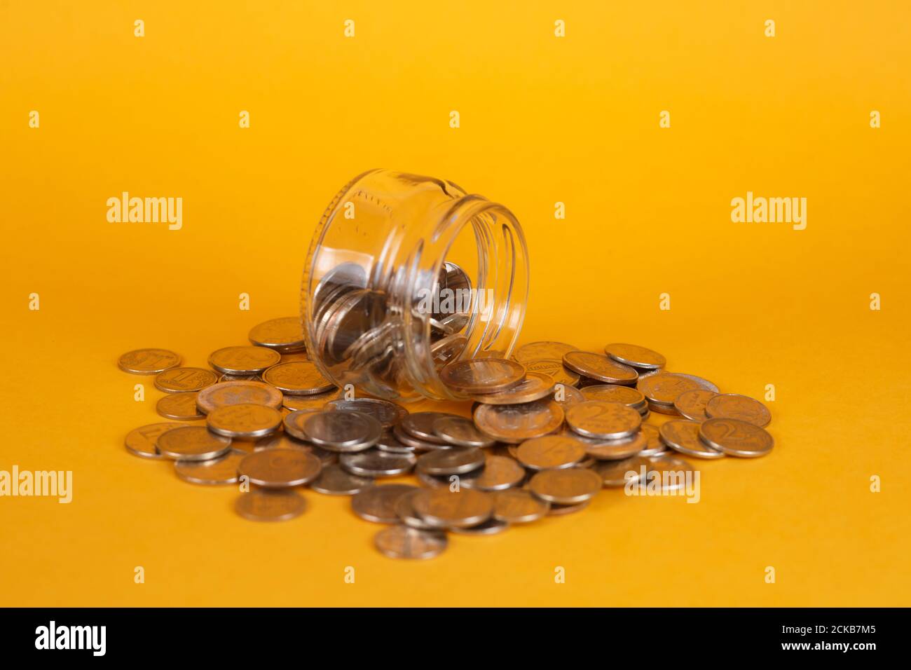 salva le finanze accumulandole. vaso di vetro su sfondo giallo Foto Stock