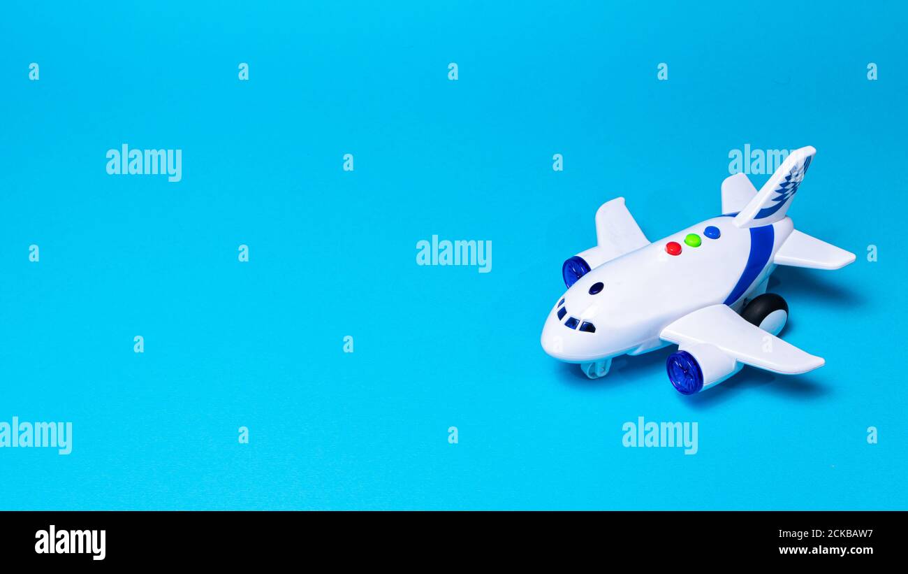 Piano bianco giocattolo su uno sfondo blu con un posto per il testo di un negozio di giocattoli e compagnie aeree. Aereo CopySpace Foto Stock