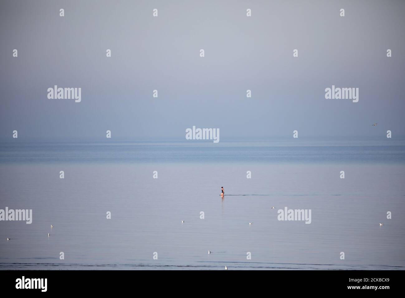 Heacham, Regno Unito. 15 settembre 2020. Il mare è magnificamente calmo mentre una signora cammina attraverso di esso a bassa marea questa mattina a Heacham, Norfolk, come una giornata calda è prevista. Credit: Paul Marriott/Alamy Live News Foto Stock