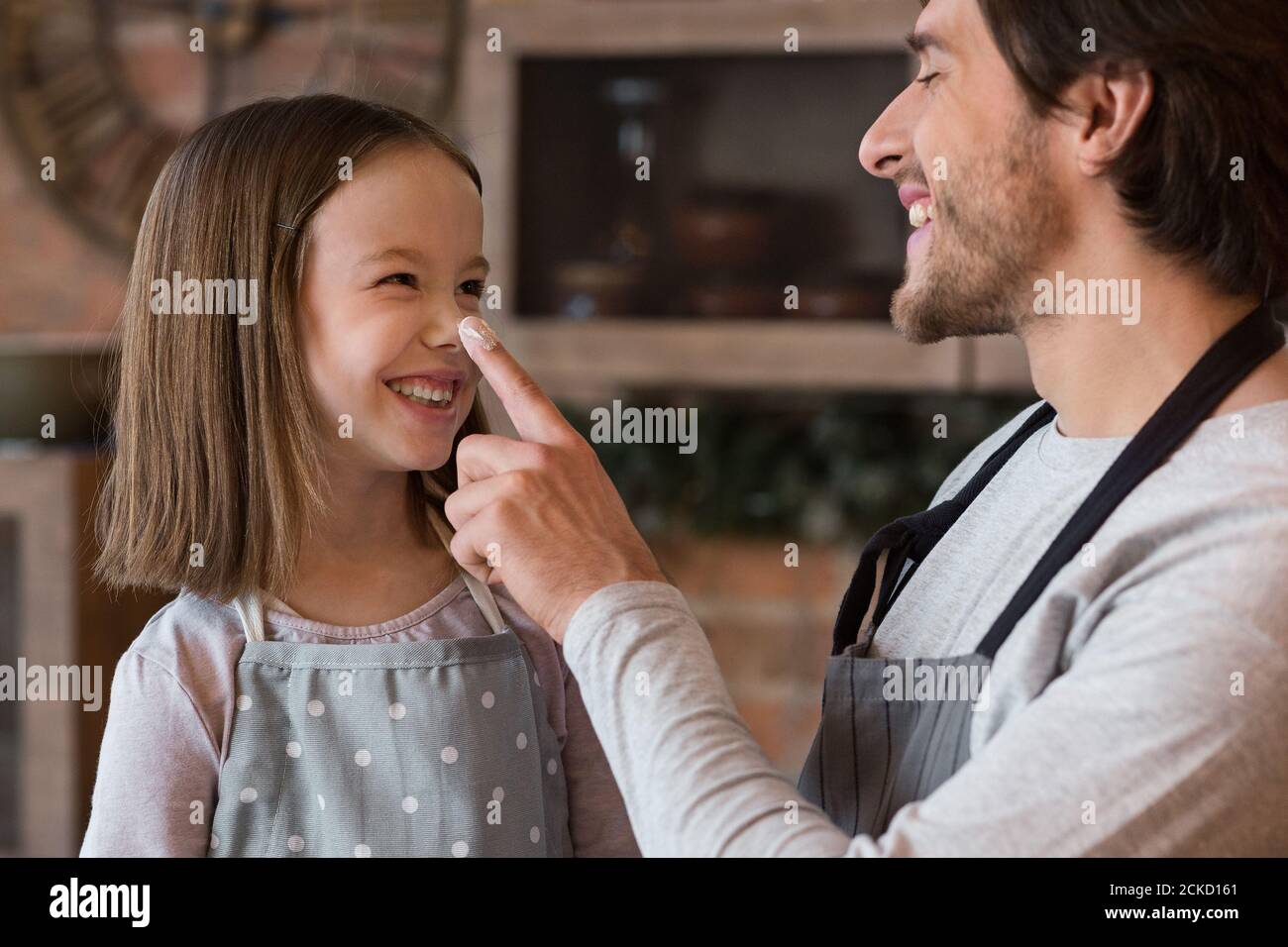 Allegra piccola ragazza e il suo giovane papà divertirsi dentro Cucina insieme Foto Stock