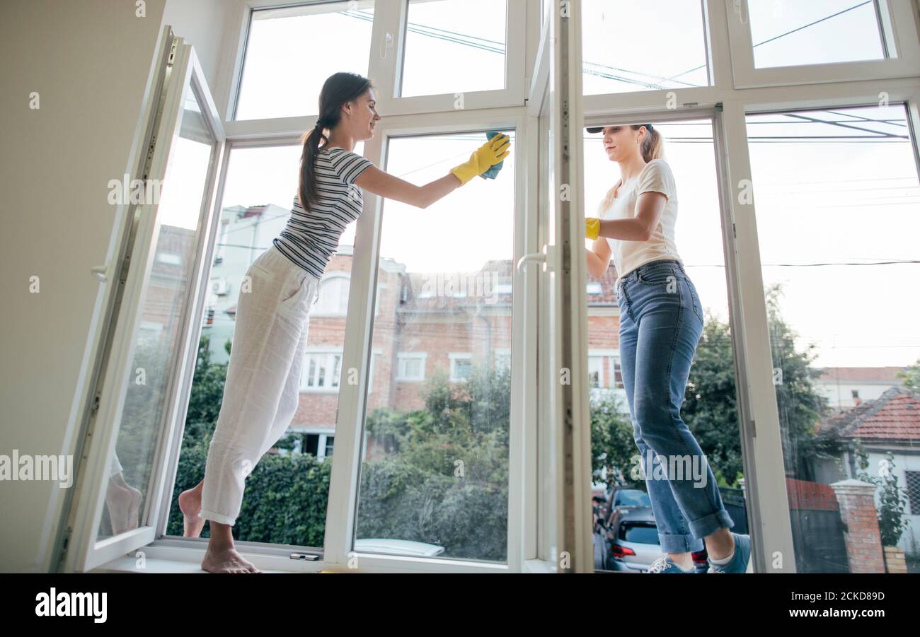 Due ragazze che puliscono le finestre. Housecleaning, concetto di casalinghi Foto Stock