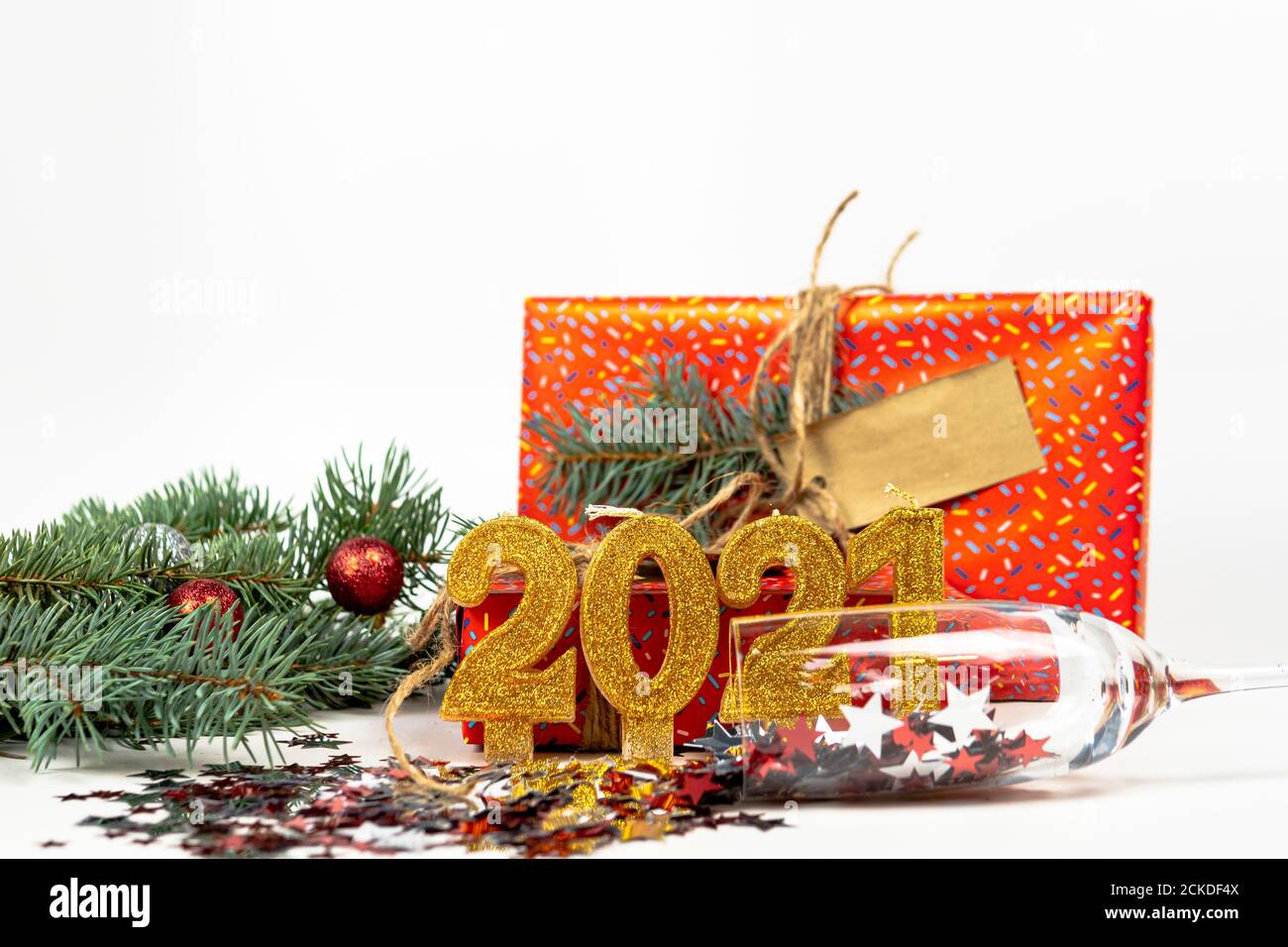 Sfondo delle vacanze con il testo del numero d'oro 2021, confetti, scatola regalo e ramo dell'albero di Natale sono sullo sfondo. Felice anno nuovo e hol Foto Stock