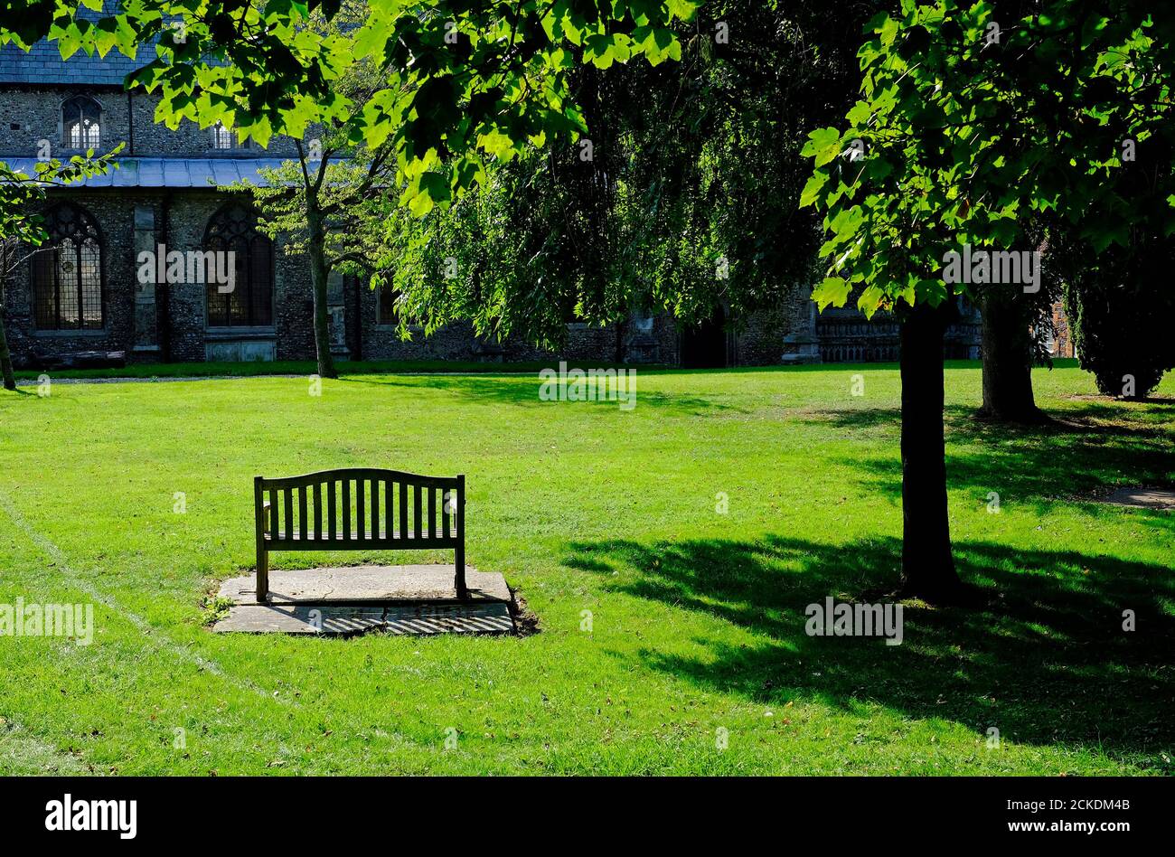 panchina vuota del parco in churchyard, fakenham, norfolk, inghilterra Foto Stock