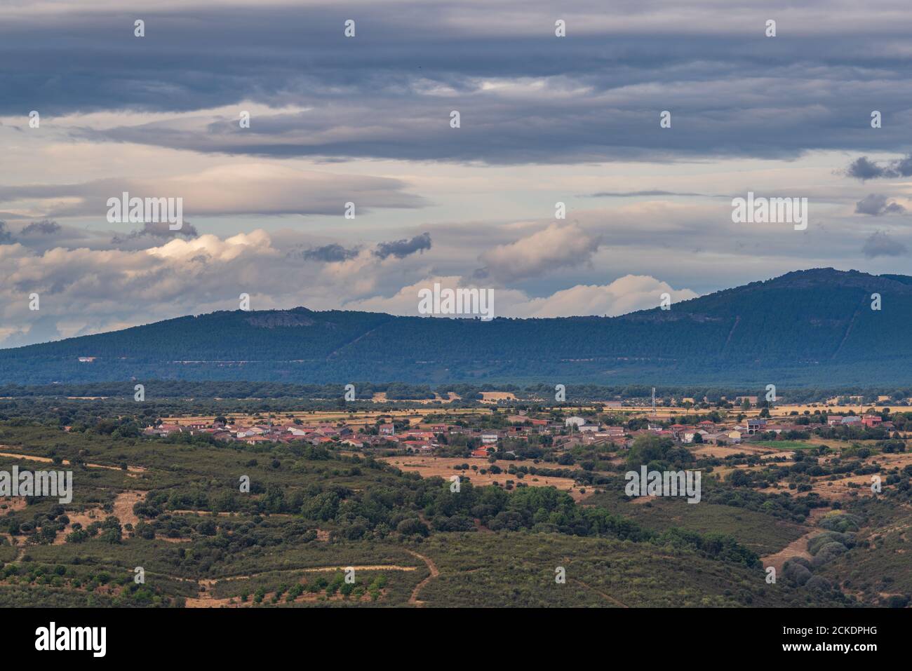 Piccolo villaggio, catena montuosa e cielo nuvoloso lungo colpo Foto Stock