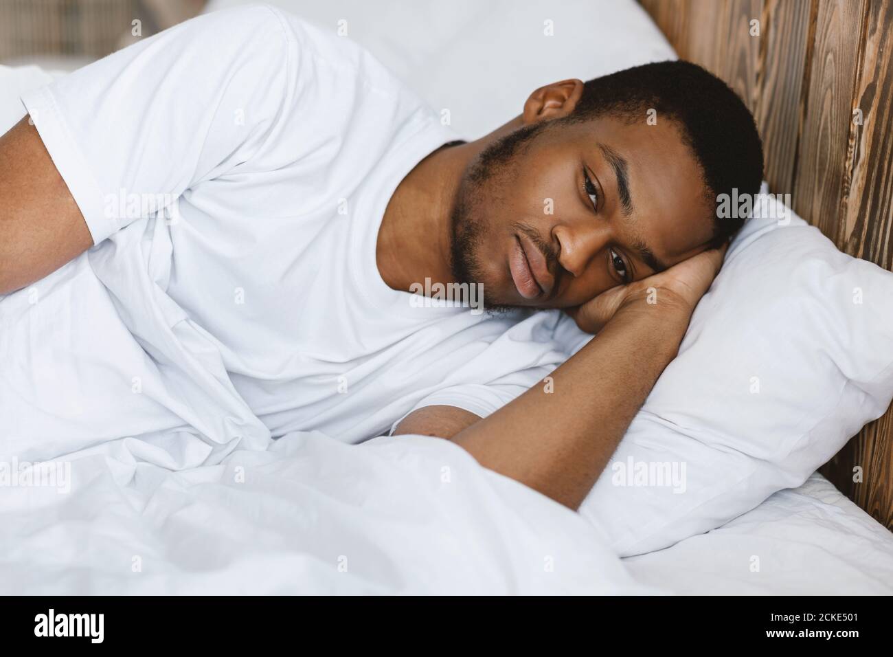 Depresso African American Man mentire Awake avendo Insomnia a casa Foto Stock