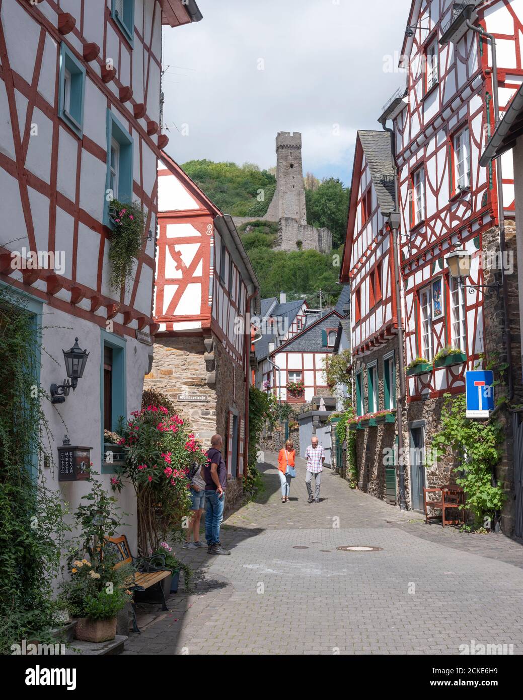i turisti camminano vicino a case a graticcio e rovine del castello Bellissimo villaggio di Monreal in tedesco eifel Foto Stock