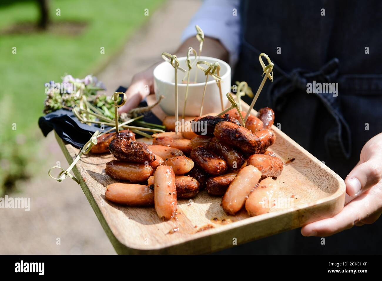 Salsicce su canapes in legno da vassoio sparati dalla vista laterale Foto Stock