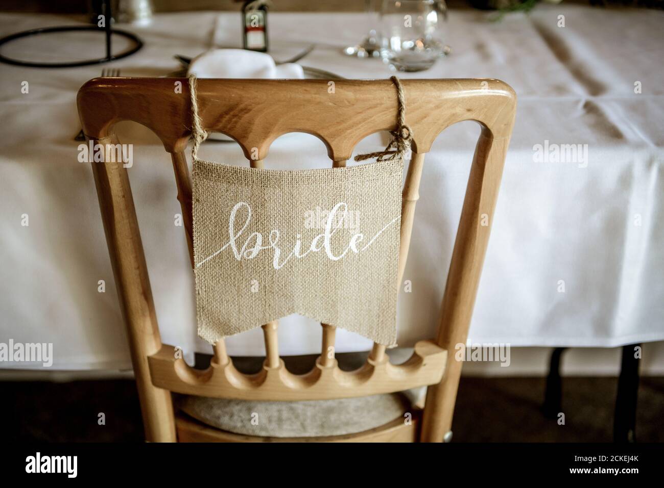 Nome Brides in bianco scritto sulla bandiera hessiana appesa sedia di legno Foto Stock