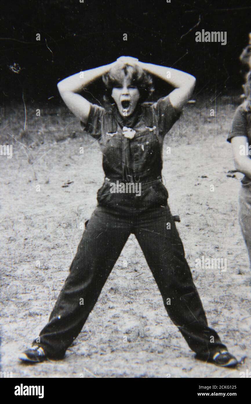 Bella fotografia in bianco e nero degli anni '70 di un adolescente gooding off durante il campeggio al campo scout estivo. Foto Stock