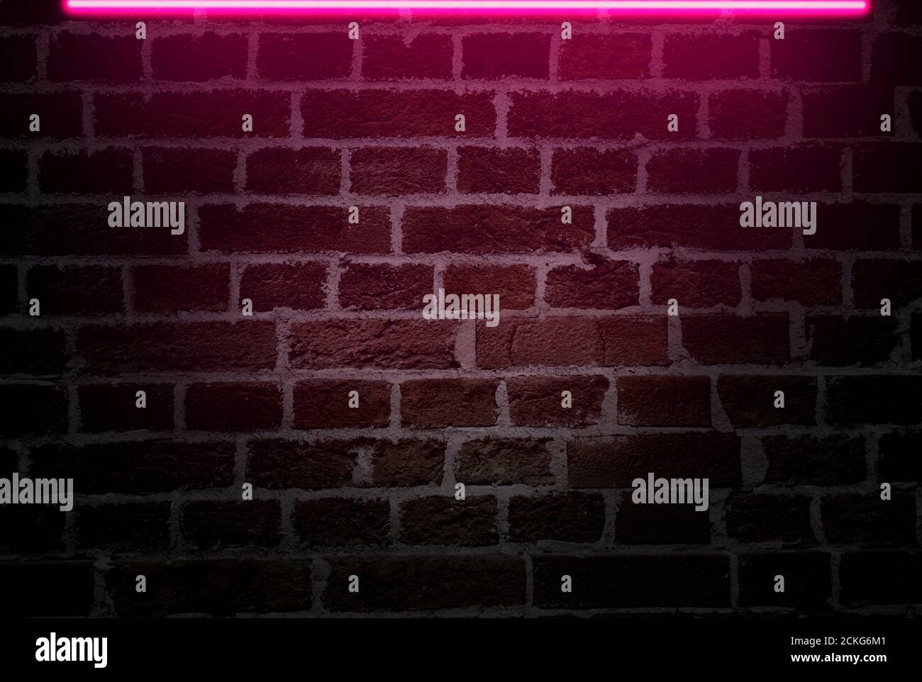 Muro di mattoni con luce al neon rosa per la pubblicità di idee Foto Stock