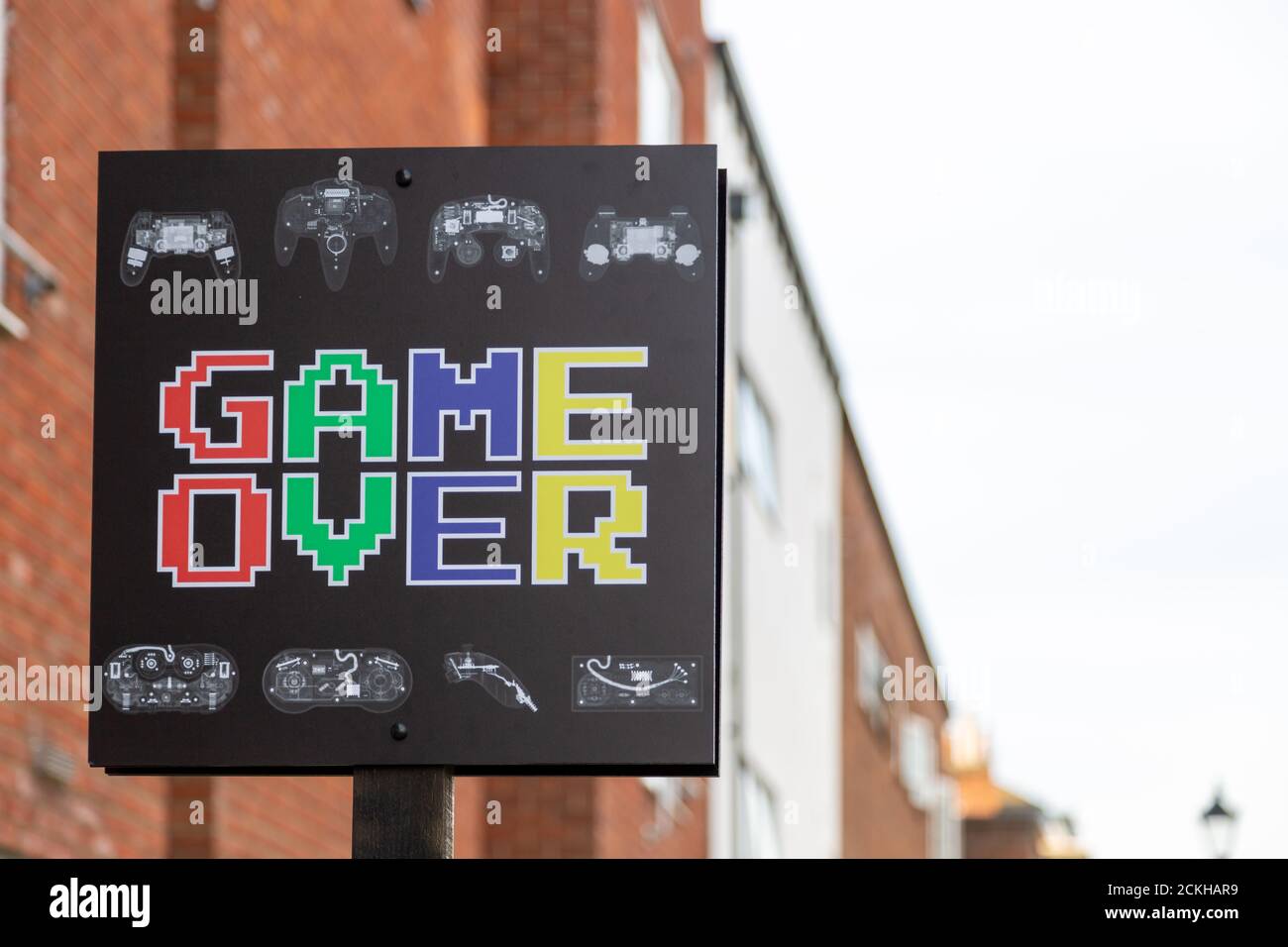 Un cartello all'esterno di un edificio con le parole Game Over su di esso in grafica stile computer Foto Stock