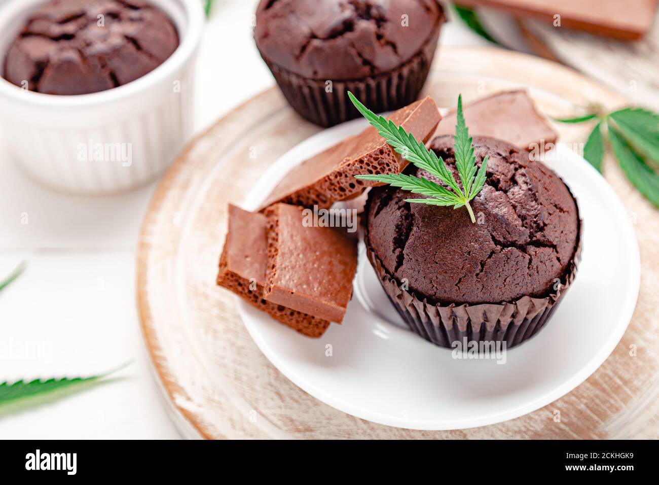 Muffin con cupcake di cioccolato alla marijuana e cbd con erbacce. Farmaci per la canapa di marijuana medica nel dessert alimentare. Muffin alle erbe infestate con cannabis, cioccolato al latte e. Foto Stock