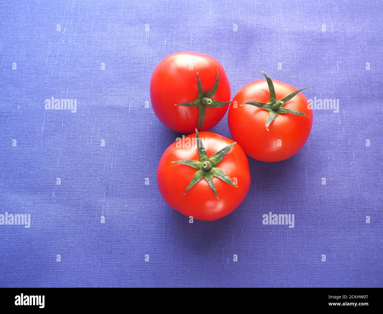I pomodori sono freschi, rossi. Tre pomodori da primo piano. Foto Stock