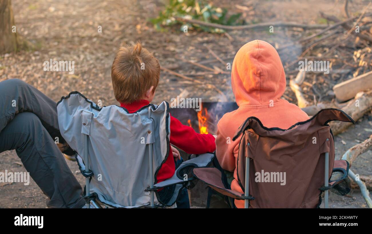 Bambini che bruciano il fuoco nel campeggio foresta durante le vacanze scolastiche invernali, Kuitpo, Australia del Sud Foto Stock