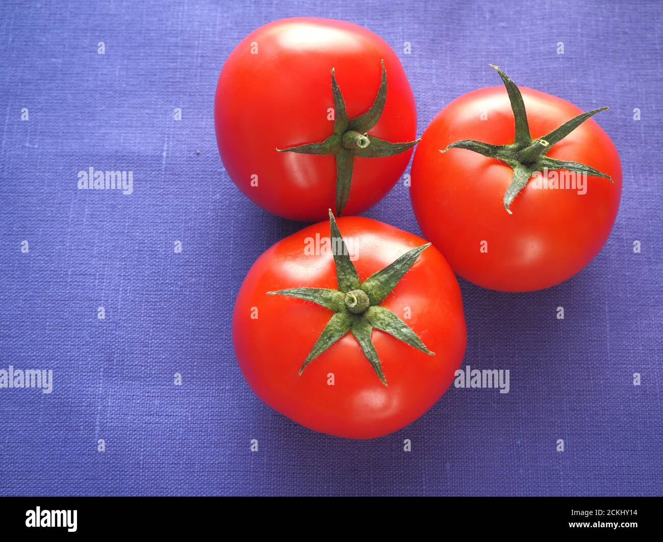 I pomodori sono freschi, rossi. Tre pomodori da primo piano. Foto Stock