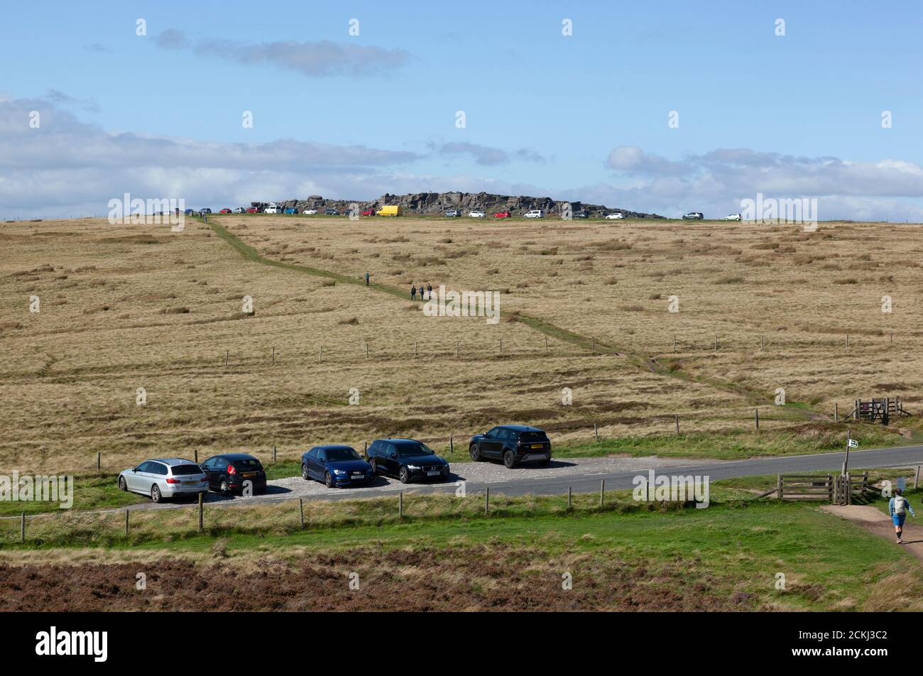 I visitatori camminano dalle loro auto parcheggiate sulle brughiere dell'area di Dark Peaks intorno a Stanage Rocks, Regno Unito Foto Stock