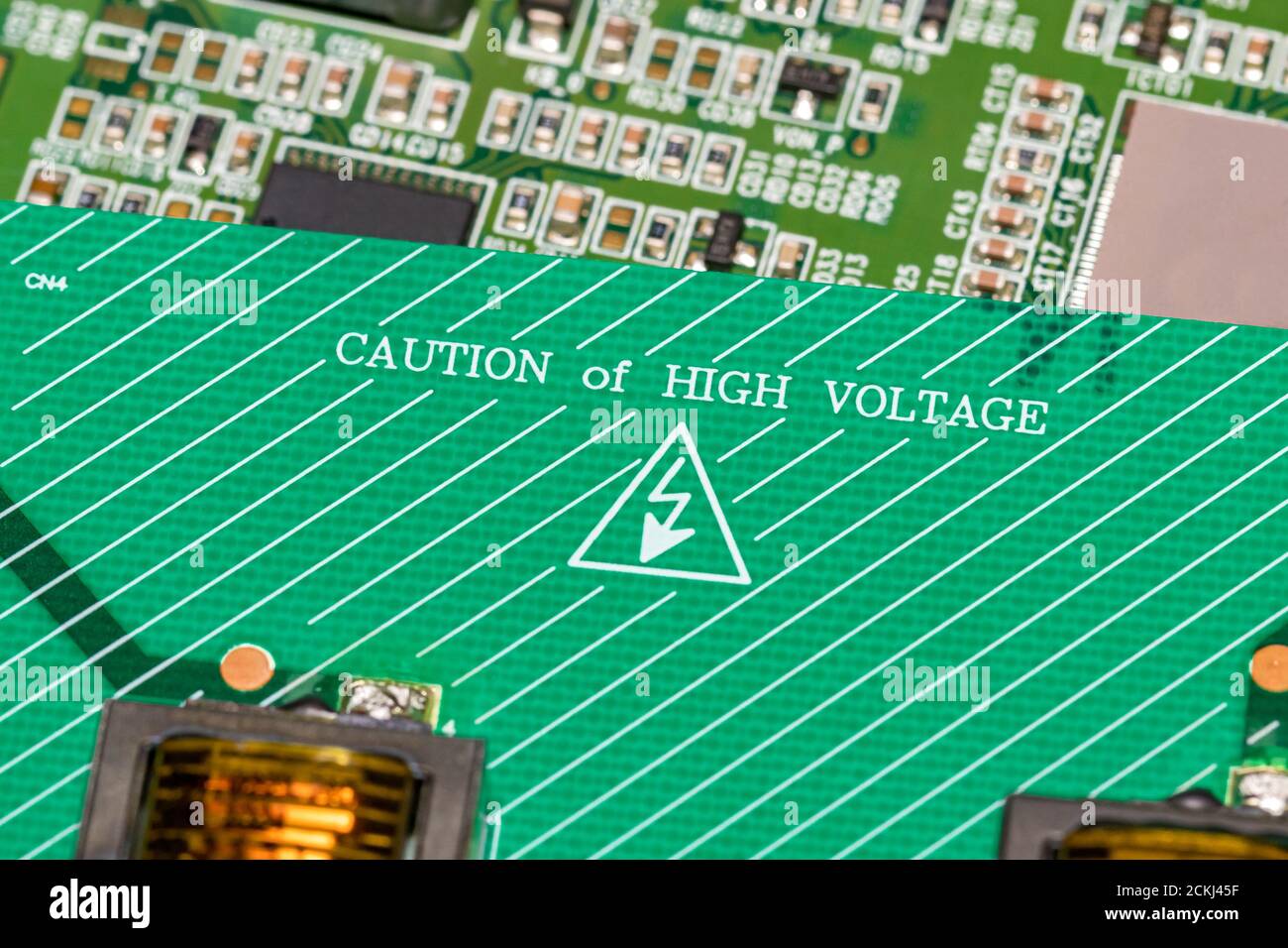 Scheda elettronica a circuito stampato con avviso di alta tensione. Concetto di riciclaggio, riparazione e assistenza di computer e televisione Foto Stock