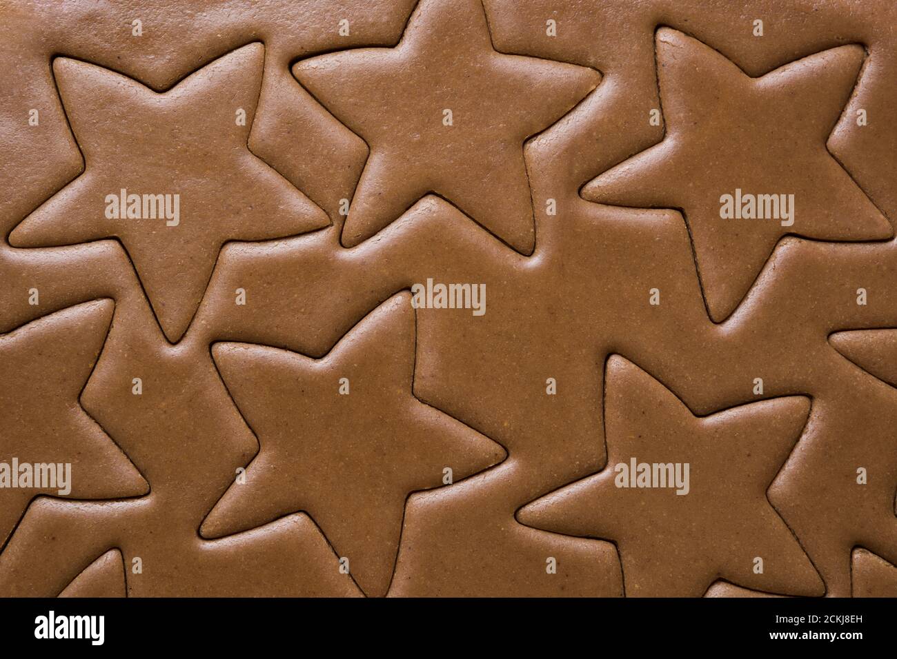 Modello di pasta cruda per biscotti di pan di zenzero a forma di stella. Fare le delizie di Natale. Foto Stock