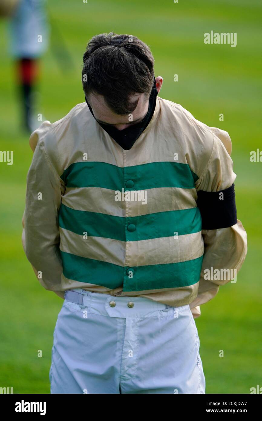 Jockey Dylan Hogan osserva un minuto di silenzio in merito al fantino irlandese Pat Smullen morto ieri. Foto Stock