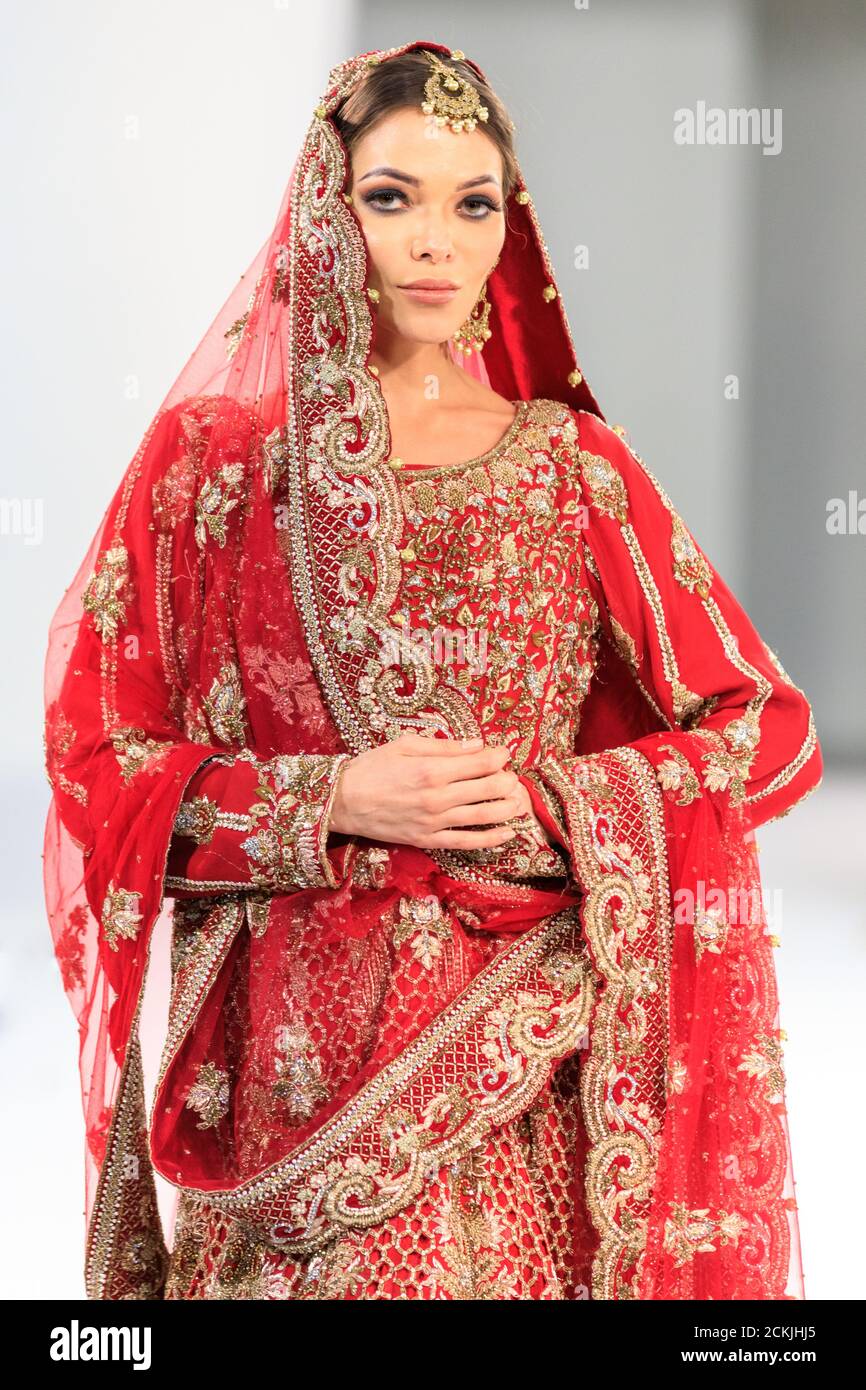 Sposa modello in abito da sposa asiatico abito da sposa, abito rosso di Sache di Asif, sfilata di moda National Asian Wedding Show, Londra Foto Stock