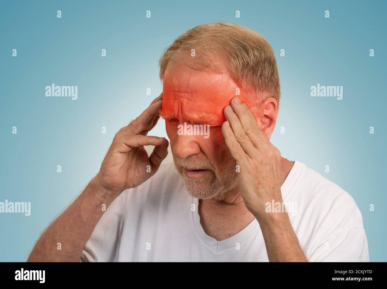 Primo piano headshot uomo anziano che soffre di mal di testa mani sulla testa con aree infiammate di colore rosso che guardano verso il basso isolato su sfondo azzurro. Huma Foto Stock