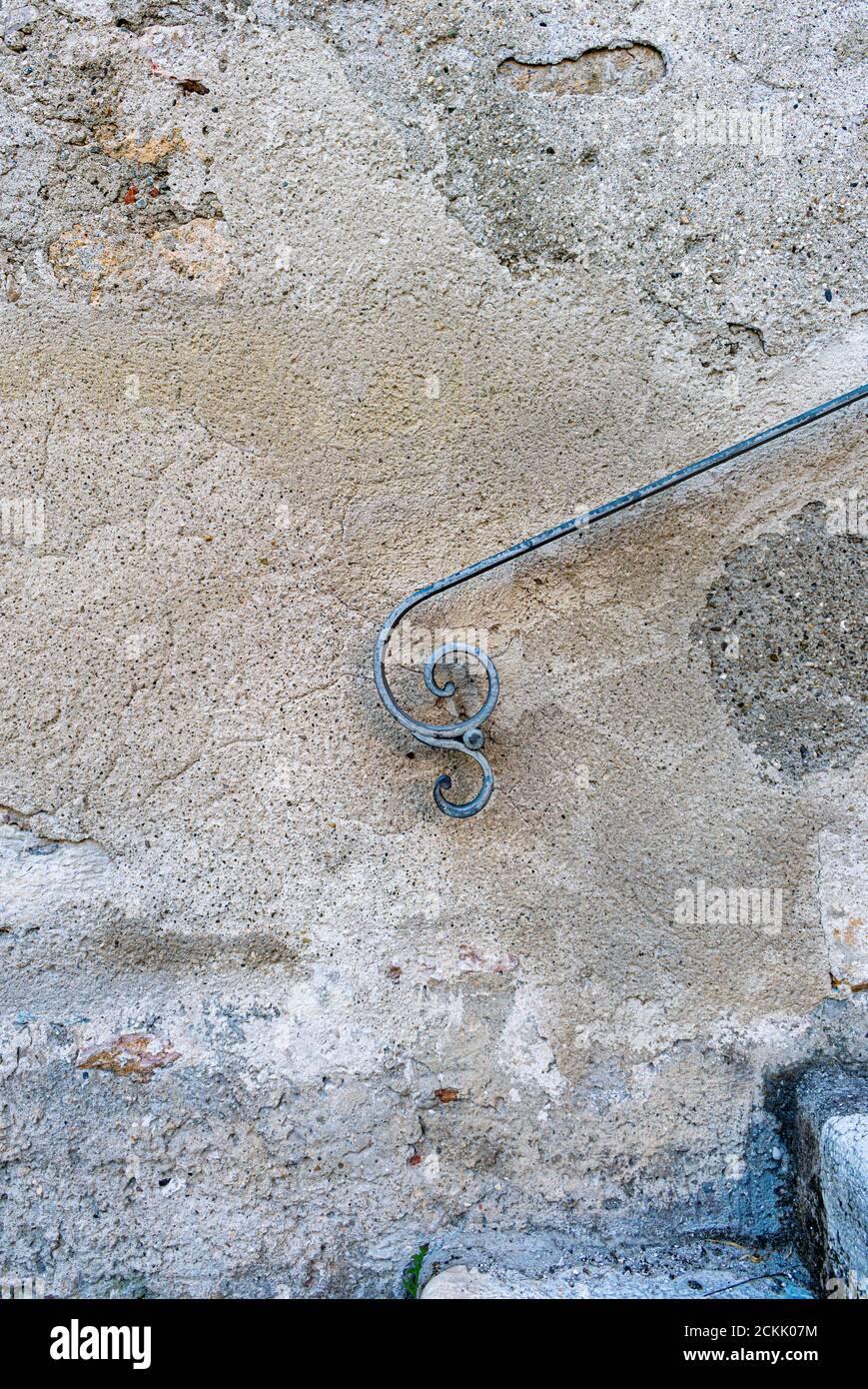 Parete esterna con dettagli di vecchio corrimano in ferro battuto con la forma stilizzata di una persona che vola Foto Stock