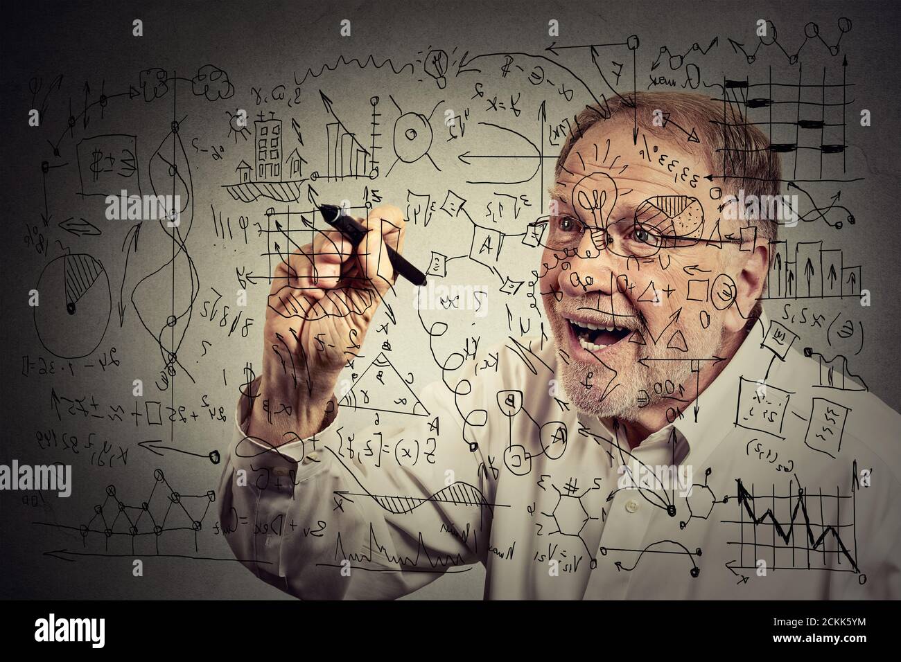 Uomo anziano scienziato con gli occhiali che scrivono la formula segreta con la penna Foto Stock